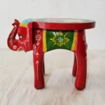Handcrafted wood elephant stool with hand-painted bone inlay, used as side table in living room