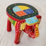 Handcrafted wood elephant stool with hand-painted bone inlay, used as side table in living room