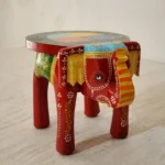 Handcrafted wood elephant stool with hand-painted bone inlay, used as side table in living room