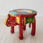 Handcrafted wood elephant stool with hand-painted bone inlay, used as side table in living room