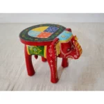 Handcrafted wood elephant stool with hand-painted bone inlay, used as side table in living room