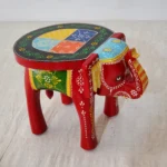 Handcrafted wood elephant stool with hand-painted bone inlay, used as side table in living room