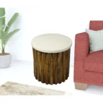 Marble round end table with brown solid wood base and ivory marble top in a living room setting