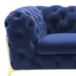 Blue velvet loveseat with gold legs and diamond tufting in a living room