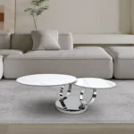 White ceramic coffee table 32 inch round with silver metal base in modern living room setting