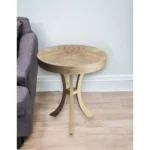 Goldoma 26 inch beige distressed round three-leg end table in a living room setting