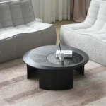 Goldoma modern round coffee table with hammered glass top and wood accents in a living room