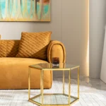 Modern hexagonal glass coffee table with stainless steel frame in a living room setting