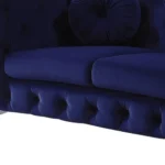 Blue velvet chesterfield loveseat with tufted cushions and silver legs in a living room
