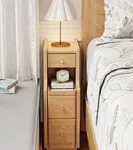 Goldoma C-shaped end table with lockable wheels in natural wood finish, placed under a sofa as a rolling side table