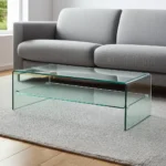 Goldoma 43-inch glass sled coffee table with brass frame and lower shelf in a modern living room