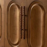 Goldoma gold sideboard buffet cabinet with solid wood arched doors and gold hardware in a modern dining room