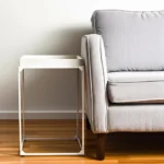 Goldoma 29-inch white solid wood end table with iron frame and tray top in a living room setting
