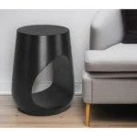 Goldoma black solid wood round end table with geometric cutout in a modern living room