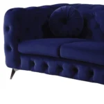 Blue velvet chesterfield loveseat with tufted cushions and silver legs in a living room