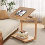 Goldoma C-shaped end table with lockable wheels in natural wood finish, placed under a sofa as a rolling side table
