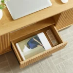 Modern oval coffee table with drawers and shelf in natural solid wood placed in living room