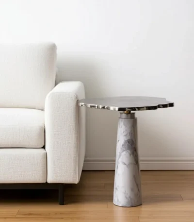 Goldoma pedestal end table with silver cast aluminum top and white marble base in a modern living room setting