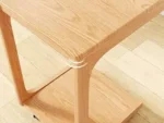 Goldoma C-shaped end table with lockable wheels in natural wood finish, placed under a sofa as a rolling side table