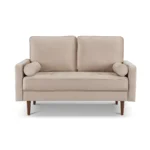 Goldoma 57-inch beige velvet loveseat with tufted seat, track arms, dark brown wood legs, and two toss pillows in a modern living room