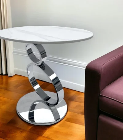Goldoma 21 inch round pedestal end table with white faux marble top and silver stainless steel base in a living room setting
