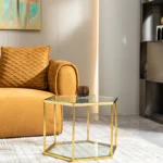 Modern hexagonal glass coffee table with stainless steel frame in a living room setting