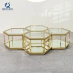 Modern hexagonal glass coffee table with stainless steel frame in a living room setting