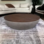 Goldoma 48-inch round solid wood and concrete coffee table with brown top and gray base in a living room