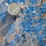 Goldoma oval blue fiberglass coffee table with marble-like finish in a modern living room