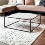 Goldoma 36 inch genuine marble coffee table with white marble top and black metal base in a modern living room setting