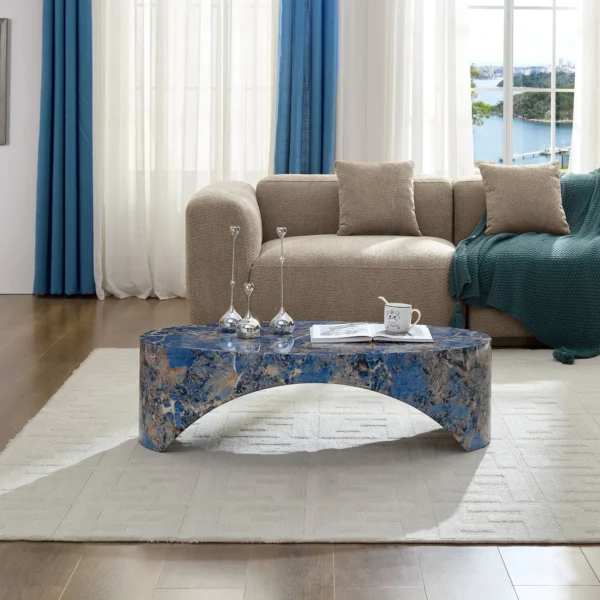 Goldoma oval blue fiberglass coffee table with marble-like finish in a modern living room