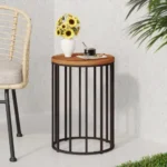 Goldoma 15 inch round solid wood outdoor side table with black metal frame on a patio