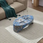 Goldoma oval blue fiberglass coffee table with marble-like finish in a modern living room
