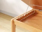 Goldoma C-shaped end table with lockable wheels in natural wood finish, placed under a sofa as a rolling side table