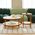 Modern farmhouse nesting coffee table set with ribbed glass tops and copper accents on a living room floor