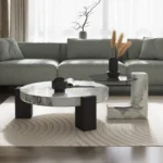 Goldoma modern round coffee table with white MDF base and clear glass top in a living room setting