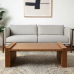 Solid wood coffee table with natural finish and sled base in a modern living room