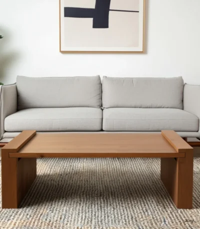 Solid wood coffee table with natural finish and sled base in a modern living room