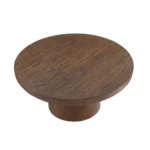 Modern round coffee table with wood veneer top and cylindrical legs in a living room setting