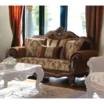 Brown damask chesterfield loveseat with genuine leather, rolled arms, and two toss pillows