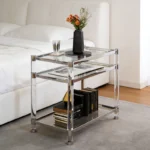 Goldoma 3-tier acrylic coffee table with tempered glass top and stainless steel frame in a modern living room setting