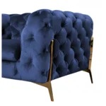 Blue velvet loveseat with gold legs and diamond tufting in a living room