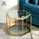 Modern hexagonal glass coffee table with stainless steel frame in a living room setting