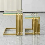 Goldoma gold coffee table set with tempered glass top and gold stainless steel frame in a modern living room