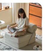 Goldoma Folding Lazy Sofa Chair in modern living room with corduroy or leather upholstery, small space