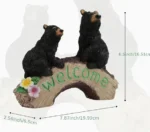 Black bear family welcome sign garden statue, resin material, displayed on a wooden porch with potted plants.