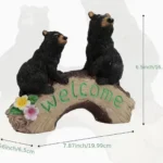 Black bear family welcome sign garden statue, resin material, displayed on a wooden porch with potted plants.