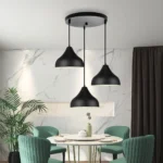 Pendant lights installed in a modern living room, casting warm light over a cozy sofa.