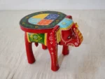 Handcrafted mango wood elephant ottoman stool with hand-painted Rajasthani folk art used as a bohemian side table in living room
