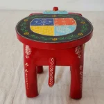 Handcrafted mango wood elephant ottoman stool with hand-painted Rajasthani folk art used as a bohemian side table in living room